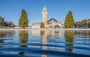 Gare des Bénédictins à Limoges, tour horloge et dôme reflétés dans l'eau, ciel bleu